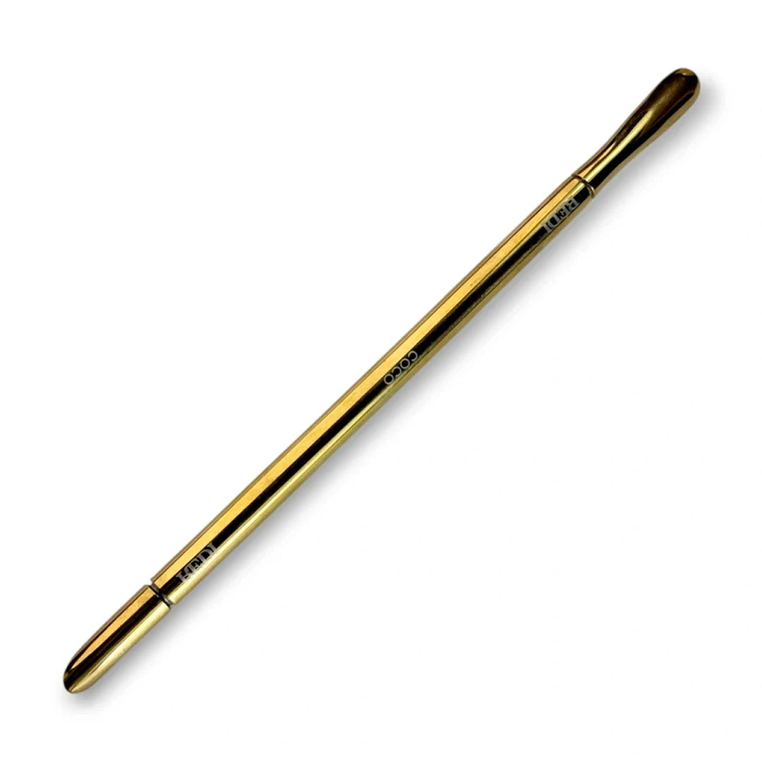 Gold double ended cuticle pusher on a white background